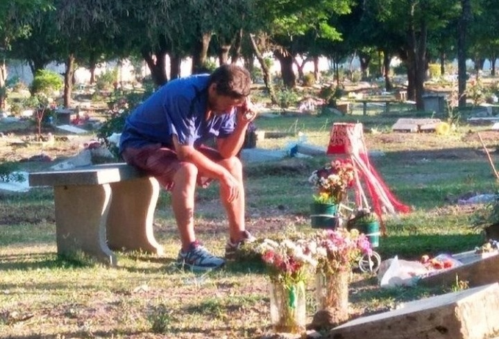 un hombre escucha todos los domingos partidos de futbol frente la tumba de su hijo