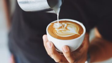 Un hombre sordo es sorprendido por una camarera mientras bebe café