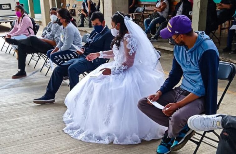 Vestidos de novios, una pareja se vacuna contra el Covid-19